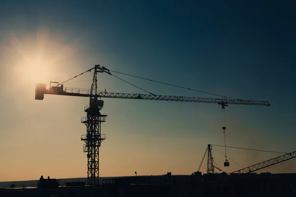 Torre guindaste silhueta na área de construção — Fotografia de Stock