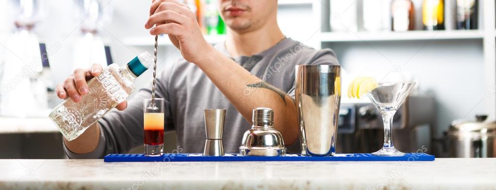 Barman's hands mixing shot cocktail