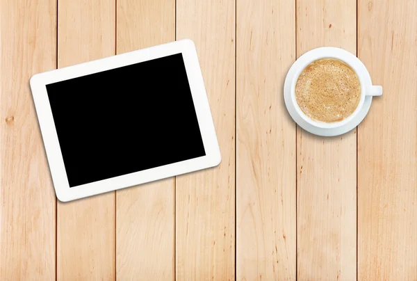 Tablet e café em uma mesa de madeira — Fotografia de Stock