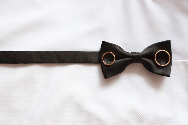 Groom bow-tie closeup with rings