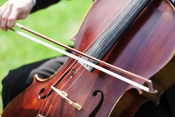 Man's hands playing violoncello outdoors — Stock Photo, Image