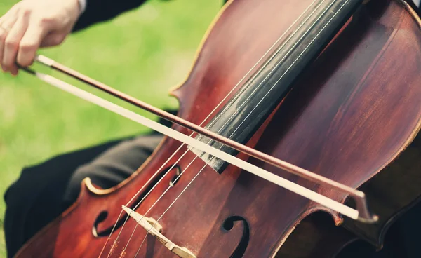 Le mani dell'uomo che suonano violoncello all'aperto — Foto Stock