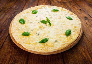 Lezzetli dört peynirli pizza ile fesleğen yaprakları