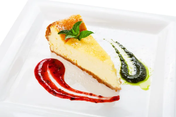 Restaurant dessert - cheesecake with mint and berry sauces — Stock Photo, Image