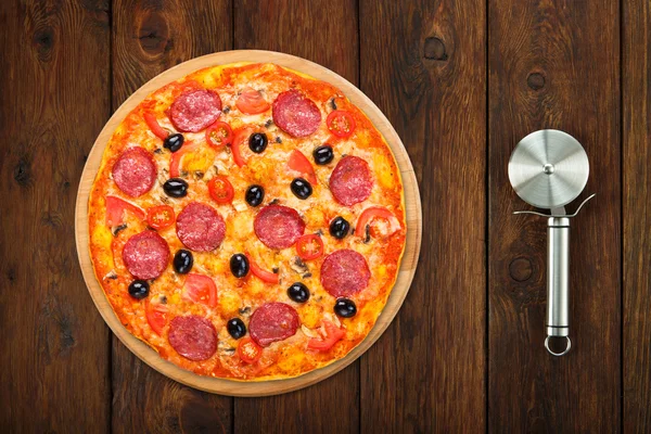 Leckere Pizza mit Salam und Champignons mit Stahlschneider — Stockfoto