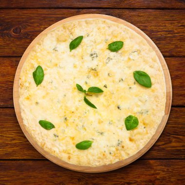 Lezzetli dört peynirli pizza ile fesleğen yaprakları