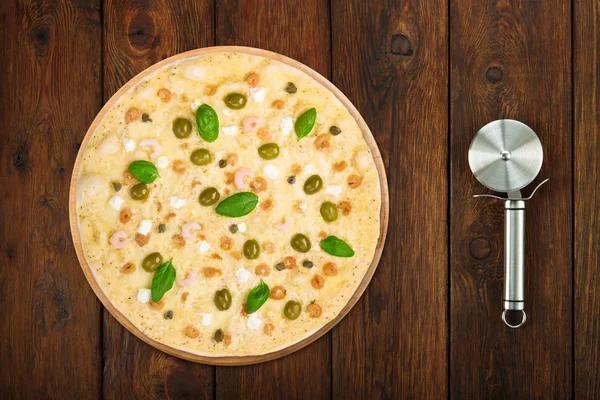 Delicious seafood pizza with olives steel cutter — Stock Fotó