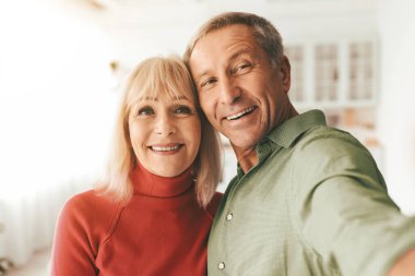 Mutlu son sınıf çifti Selfie çekiyor. Birlikte poz veriyorlar. Evde kameraya gülümsüyorlar. Olgun eşler fotoğraf çekip eğleniyorlar. Emeklilik Yaşamı, Evlilik ve Aile Anları