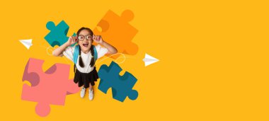 Gözlüklü bir çocuk, renkli yapboz parçaları ve kağıt uçaklarla çevriliyken ışıl ışıl gülümser. Bu kolaj, yaratıcılığın geliştiği bir okul ortamında öğrenmenin hazzını temsil ediyor..