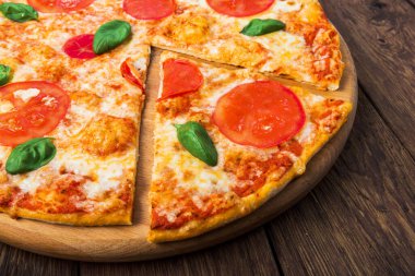 Domatesli Margherita pizza ve ahşap arka planda mozarella, yakın plan.