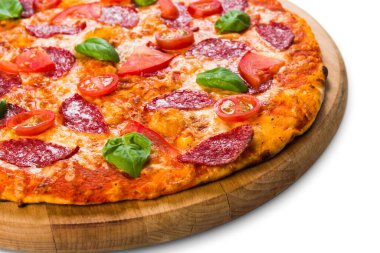Salamlı, pepperonili ve kiraz domatesli lezzetli pizza. Tahta tahtada beyaz arka planda izole edilmiş ince hamur kabuğu.