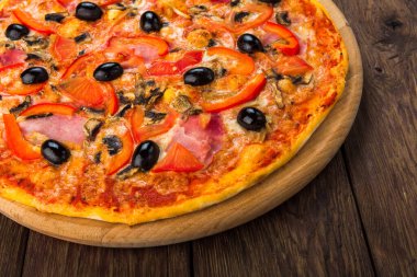 İtalyan pizza closeup jambon, domates ve Siyah Zeytin - pasta kabuk ahşap masa arka plan, ince