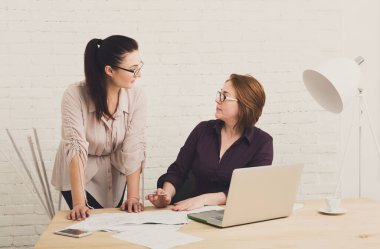 İki kadın ofiste. Takım çalışması, iletişim iş. Takım çalışması tasarımcılarında orta yaşlı Mimarlar projeyi tartışmak. Tartışma başlatmak. Kadın arkadaşları.