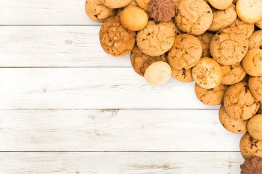 Kurabiye ve tatlı bisküvi, beyaz tahta, arka plan kopya alanı ile. Yulaf ezmesi ve çikolata damla kurabiye sınır tatlı çay için.