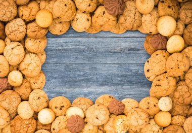 Cookies frame background. Sweet chocolate chips biscuits on blue rustic wood with copy space.