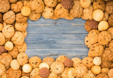 Cookies frame background. Sweet chocolate chips biscuits on blue rustic wood with copy space.
