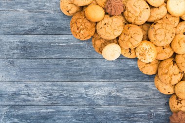 Tanımlama bilgileri arka plan. Mavi rustik ahşap arka plan kopya alanı ile tatlı çikolata bisküvi yığın. Yulaf ezmesi, çikolatam damla ve diğer tatlılar. Besi tatlı çay ahşap masa en iyi görünüm için