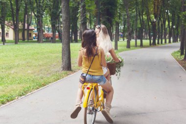 Mutlu kız Bisiklet eğleniyor. Arkadaşlar, gençlik ve mutluluk, etkin yaz eğlence parkı kavram.