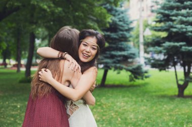 Arkadaşlar mutlu boho kızlar birbirlerine sarılmak, kucaklamak. Kadın dostluk, park açık havada yürüyüş