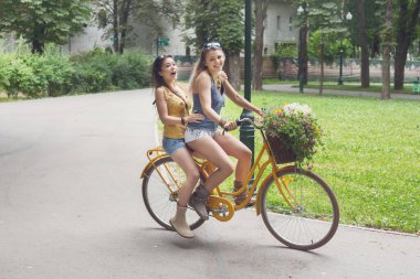 Mutlu kız Bisiklet eğleniyor. Arkadaşlar, gençlik ve mutluluk, etkin yaz eğlence parkı kavram.
