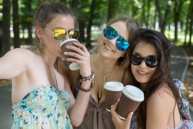 Kahve siparişiyle eğlenen genç kızlar. Yaz şehrinde selfie çekmek