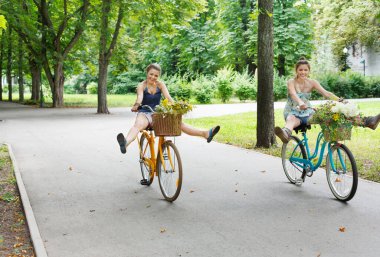 Mutlu kız Bisiklet eğleniyor. Arkadaşlar, gençlik ve mutluluk, etkin yaz eğlence parkı kavram.