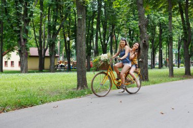 Mutlu kız Bisiklet eğleniyor. Arkadaşlar, gençlik ve mutluluk, etkin yaz eğlence parkı kavram.