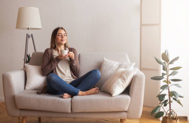 Sonunda kahve. Genç kahve aşığı sıcak içeceği kokluyor. Evin içinde, boş bir yerde.