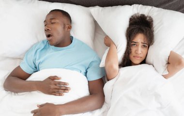 Horlayan bir adam apne ve uykusuz bir kadınla yatıyor, kızgın bir eş uyuyamıyor. Üzgün genç Afrikalı Amerikalı kadın yatak odasındaki horlayan adamın sesini duymamak için kulaklarını yastıkla kapatıyor.