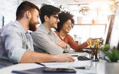 İyi iş çıkardın. Modern ofisteki bilgisayarda iyi kodlama işinden zevk alan üç adam, boş alan.