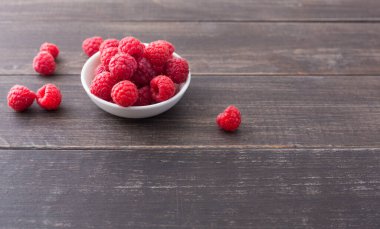 Rustik ahşap arka plan üzerinde kopya alanı ile Ahududu kase.