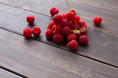 Taze ahududu ahşap arka plan üzerinde. Ahşap masa üzerinde doğal olgun organik çilek closeup ile kase