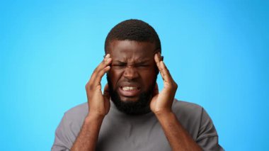 Genç bir Afrikalı Amerikalı sıkıntılı görünüyor. Kafasını tutarak hayal kırıklığı ya da rahatsızlık hissediyor. Migren ve baş ağrısı çekiyor.