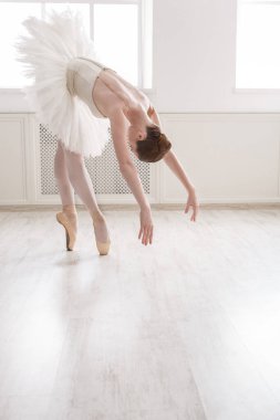 Klasik Bale dansçısı. Beyaz ışıklı salonda geniş pencerenin yanında etekli güzel bir balerin pratiği. Bale sınıfı eğitimi, yüksek notalı yumuşak tonlama.