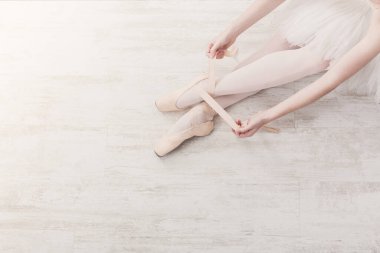 Bale eğitimi geçmişi. Güzel balerin bacakları, beyaz ahşap zeminin üst manzarası.