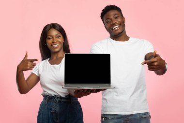 Pembe bir stüdyo geçmişinde, neşeli bir Afro-Amerikalı erkek ve kadın siyah ekranlı bir dizüstü bilgisayar tutuyorlar. Ekranı gösteriyorlar, tasarım için hazırlar..