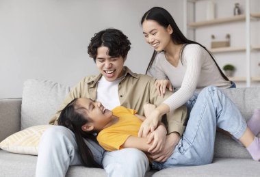 Neşeli bir aile anı, ailesi tarafından eğlendirilirken genç bir kızın kahkahalarla gülmesiyle başlar. Açık renkli bir kanepede rahatça otururlar, aşk ve mutluluğu paylaşırlar..