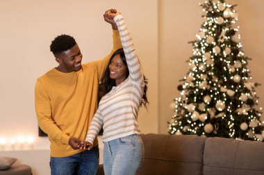 Mutlu bir siyah çift, oturma odalarında güzel ışıklandırılmış bir Noel ağacının yanında dans etmekten zevk alır. Sıcak bir atmosferde birlikte yeni yılın neşesini kutlarlar..