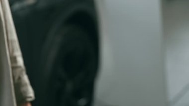 Kesilmiş bir satıcı, müşteriye yepyeni bir arabanın anahtarını verir. Atmosfer canlı, çeşitli araçlar ve özellikler sergiliyor..