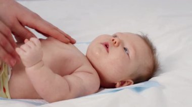 Sevgi dolu bir yetişkin, evde yeni doğmuş bir bebeğe şefkatle bakar. Sevgiyle dolu samimi bir anı gösterir. Bebek yukarıya bakıyor, bu özel bağlanma zamanının tadını çıkarıyor..