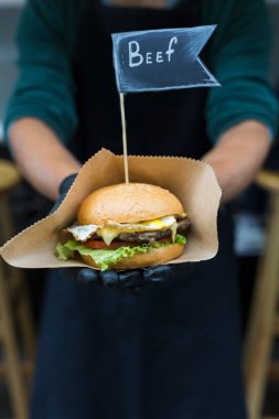 Sokak fast food festivali, açık havada barbeküde pişirilen hamburger. Izgara Amerikan bbq yemekleri, şeflerin el yapımı el yapımı kağıt ve metin etiketleri.