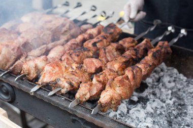 Sokak fast food festivali. Metal şişte çiğ kebap ızgarası. Biftek ve domuz ızgarada kızarır..