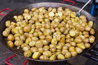 Köy yemekleri. Açık havada büyük metal bir kazanda pişirilmiş kızarmış patates. Mangal sebze yemekleri. Taze organik, ızgara ateşte pişirilmiş sağlıklı atıştırmalıklar. Sokak Fast food.