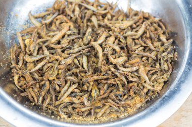 Ançüez balığı, mangalda, metal tencerede kızartılmış. Açık havada deniz ürünleri, piknik, parti. Sokak yemeği, büyük tepside götür. Limonlu kızarmış ızgara balık.