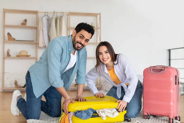İki mutlu gezgin şık bir dairede parlak bavullarını topluyor. Yaklaşan yolculukları için giysilerini ve gerekli şeyleri hazırlarken heyecanlı görünüyorlar..