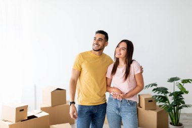 Bir çift yeni evlerinde mutlu mesut dururlar. Kutularla çevrili olarak. Gün boyunca yeni yerlerine yerleştiklerinde anın tadını çıkarırlar..