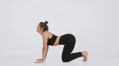 Bir kadın hareketli bir yoga pozu sergiliyor, esneklik ve vücut hizasına odaklanıyor. Bu egzersiz, sağlıklı bir yaşam tarzını desteklemek için ideal gücü ve gerilimi vurguluyor..