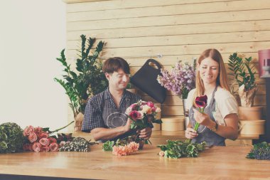 Flower shop, bouquets delivery. Florists creating order from fresh roses.
