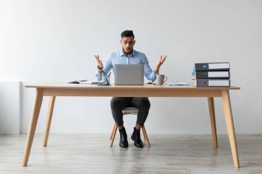 Kafası karışık bir Arap masasında oturup hayal kırıklığı içinde ellerini açıyor. Kötü haberlerle karşılaşmak için dizüstü bilgisayarına bakıyor. Evde beklenmedik iş sorunlarıyla uğraştığı için strese maruz kalıyor..