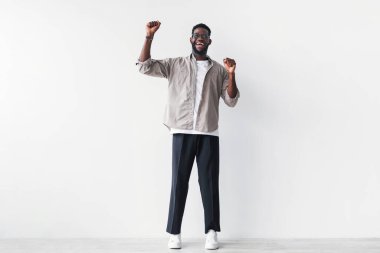 Genç siyah bir adam heyecanla bağırarak ve iki elini de kaldırarak saf mutluluğu ifade eder. Sade beyaz bir stüdyo duvarına karşı duruyor, başarılı olduğu bir anda muzaffer ruhunu sergiliyor..